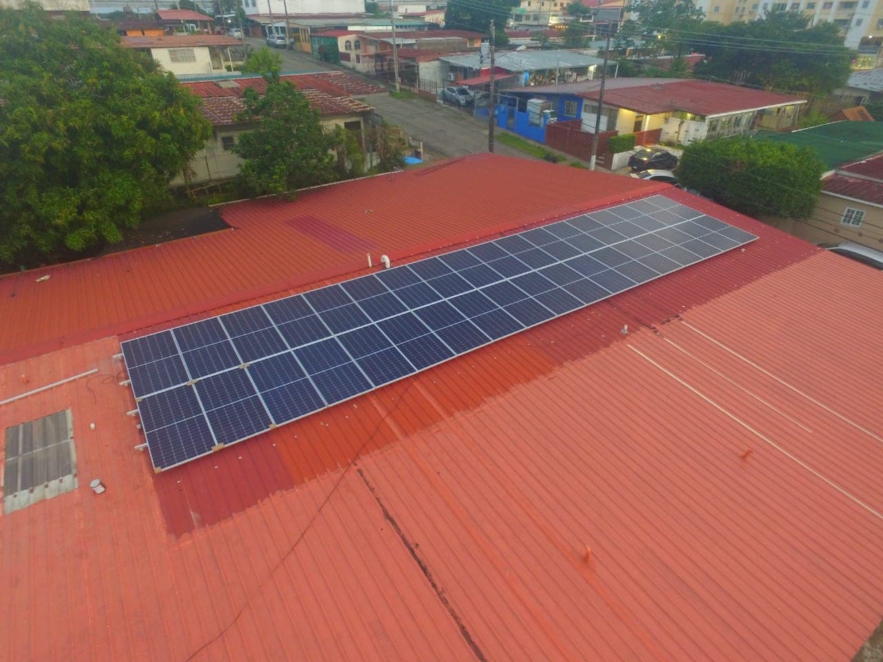 Sistema solar comercial instalado sobre techo rojo